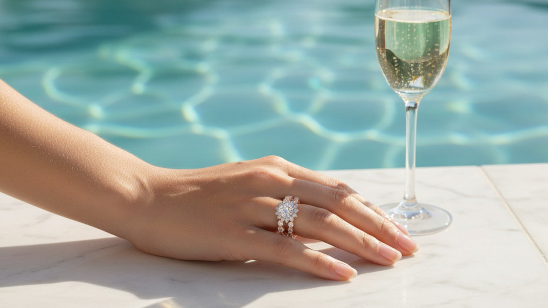 Woman's hand with moissanite eternity band and halo ring poolside with champagne